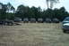 1993 Ford Bronco - Several off-road vehicles, including a 1993 Ford Bronco, are gathered in a dirt lot with a trailer.