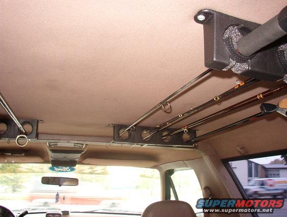 Interior view of a 1993 Ford Bronco with fishing rods stored in a ceiling rack