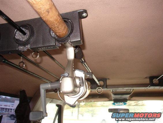 Interior view of a fishing rod holder with rods and reels attached to the ceiling of a vehicle