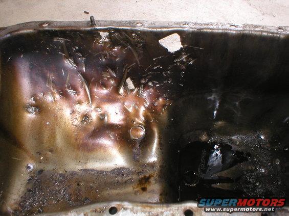 Used oil pan with heavy sludge and damage
