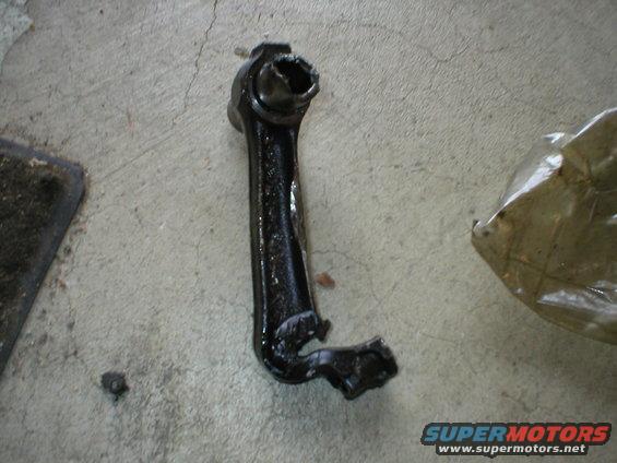 Black connecting rod with damaged end on concrete