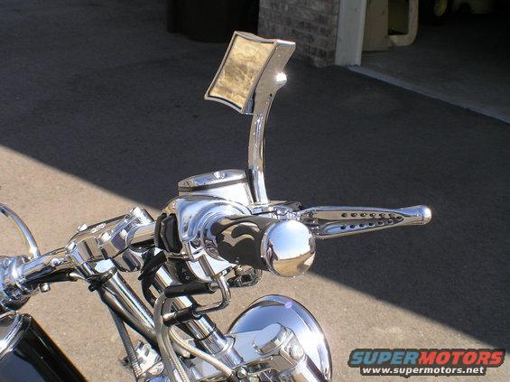 Close-up of motorcycle handlebars with chrome accents and a decorative mirror