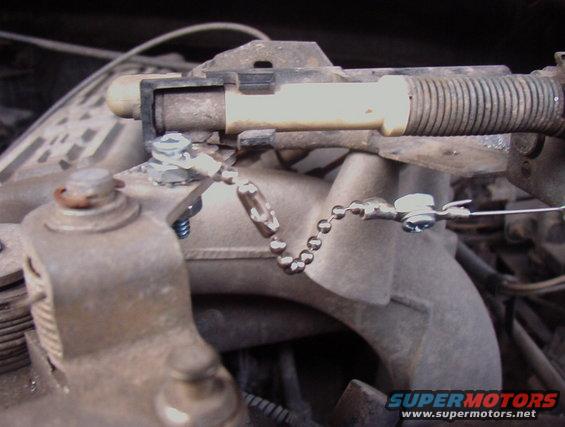 Throttle linkage with a chain and cable attached to a metal bracket