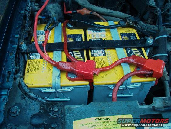 Dual yellow Optima batteries with red cables in engine bay
