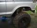 1976 Ford F-150 - Close-up of the lifted suspension and large off-road tire on a 1976 Ford F-150.