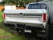 1976 Ford F-150 - The rear of a silver Ford pickup truck is shown, with the tailgate down and a black bumper.