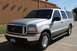 2001 Ford Excursion - This Ford Excursion is parked in front of a building with a wooden-slatted wall.