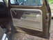 1979 Ford Bronco - Interior door panel of a 1979 Ford Bronco, showing the brown and tan trim and window crank.