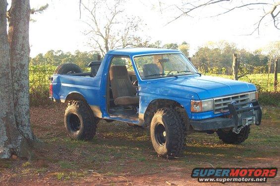 1987 Ford Bronco with lifted suspension and off-road tires, parked outdoors