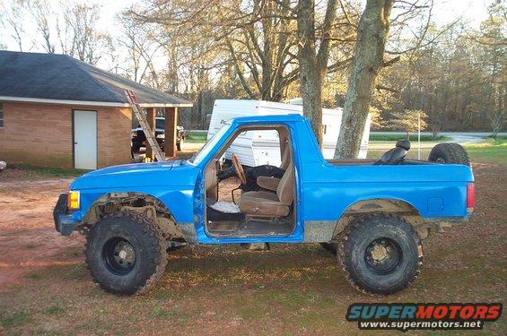 1987 Ford Bronco with doors removed, sitting in a yard