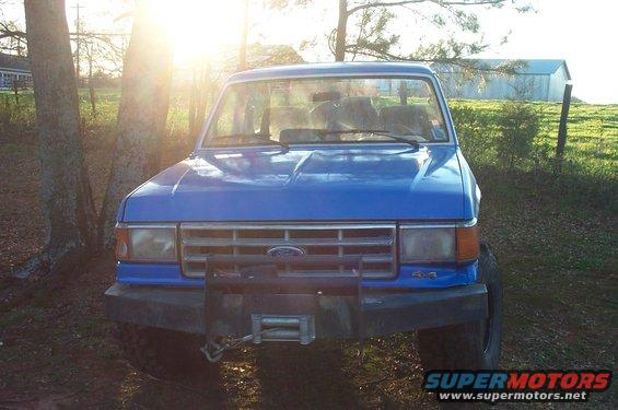 Blue 1987 Ford Bronco front view with winch and 4x4 badge
