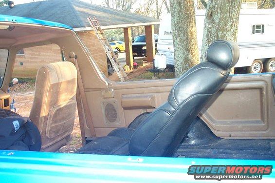 Interior view of a blue vehicle showing brown front seats and door panel