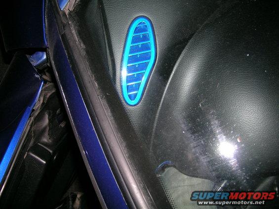 Blue illuminated vent on interior dashboard near windshield