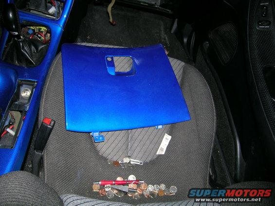 blue panel on car seat with coins and pen scattered on floor