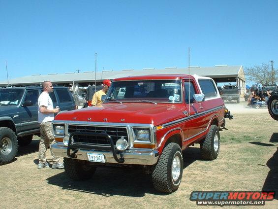 Red 1978 Ford Bronco parked outside with a blue SUV next to it