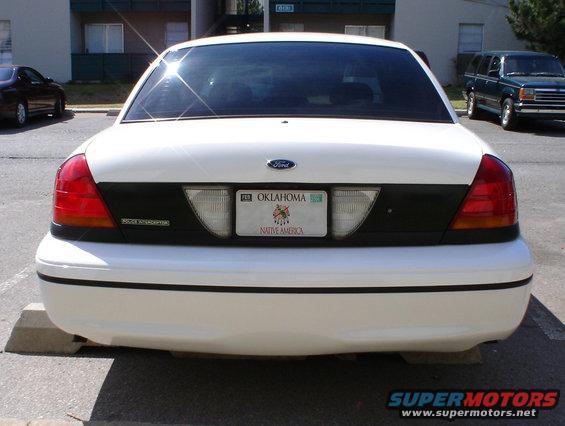 White 1998 Ford Crown Victoria rear view, license plate from Oklahoma, parked on concrete blocks