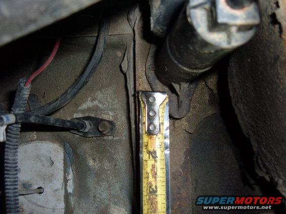 Close-up of vehicle frame with a yellow measuring tape showing approximately 2.5 inches