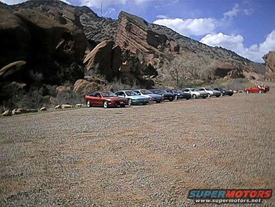 1996 Ford Probe and other cars parked in a row with red rocks behind them