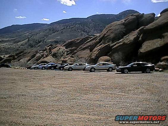 Silver 1996 Ford Probe parked in a line of cars with a rocky mountain backdrop