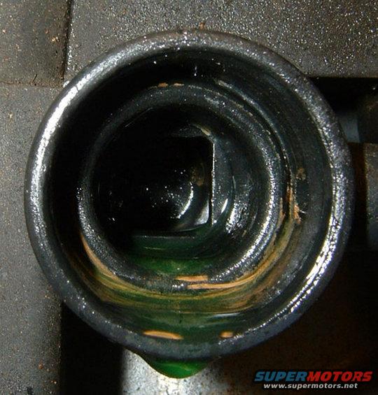 Close-up of a radiator cap opening with green fluid and some rust