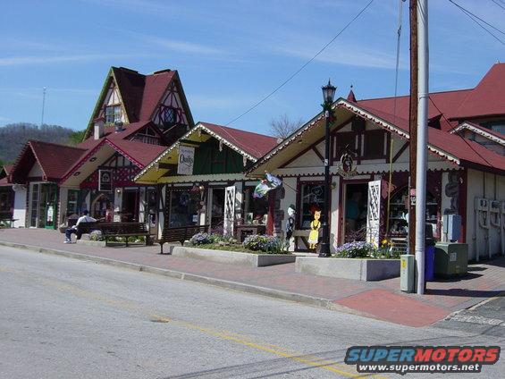 Street view of Bavarian-style shops with a person sitting on a bench