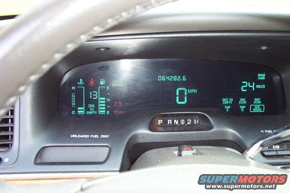 Car dashboard with digital gauges showing speed, fuel, and odometer reading 64282.6