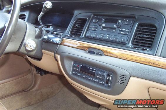 Car interior dashboard with wood trim, showing radio and climate controls