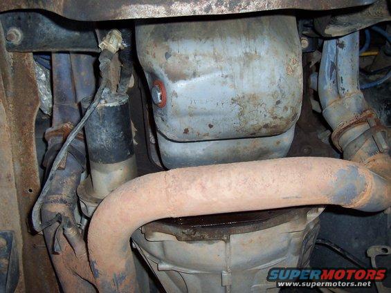 Close-up of exhaust pipes, starter motor, and transmission pan