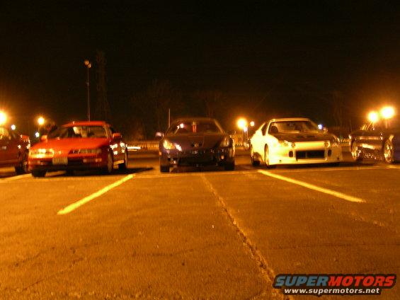 1994 Ford Probe and other sports cars parked in a lot at night
