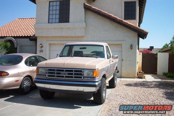 1987 Ford F-150 pickup truck parked in driveway, another car to the left