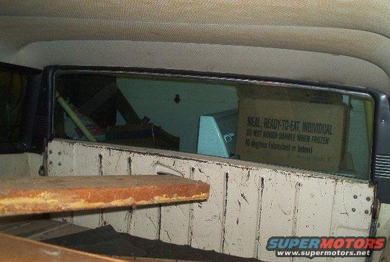 Interior view of a vehicle showing a box labeled 'MEAL, READY-TO-EAT, INDIVIDUAL' through the rear window