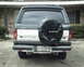1987 Ford Bronco - The rear of a 1987 Ford Bronco is visible, a spare tire cover with the Ford logo.