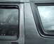 1987 Ford Bronco - Close-up of the side of a dark SUV, showing the rear door and window area.