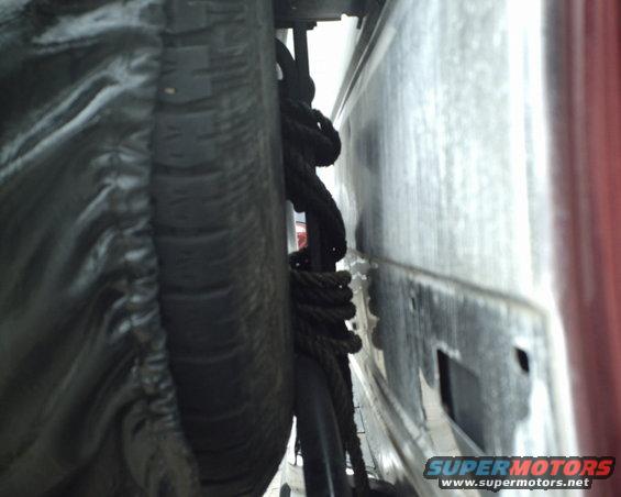 Spare tire and coiled rope secured under a vehicle