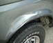 1987 Ford Bronco - The fender of a gray 1987 Ford Bronco shows a noticeable dent above the wheel well.