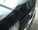 1987 Ford Bronco - Close-up of the front grille and damaged hood of a black vehicle.