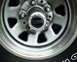 1987 Ford Bronco - A close-up view of a vehicle's wheel hub, a black center cap with visible text.