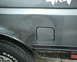 1987 Ford Bronco - The rear quarter panel of a vehicle shows a dent and a fuel door.