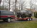 1979 Ford Bronco - A camouflaged Ford Bronco is loaded onto a trailer, towed by a pickup truck.