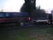 1979 Ford Bronco - A red and black pickup truck is seen from the side, towing a flatbed trailer.