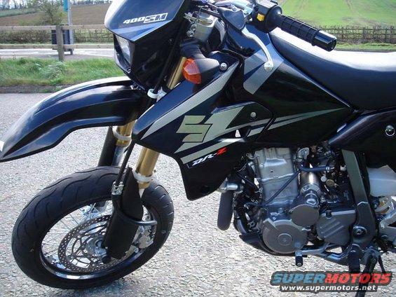 Black Suzuki DR-Z400SM motorcycle with silver graphics, gold forks, and visible engine