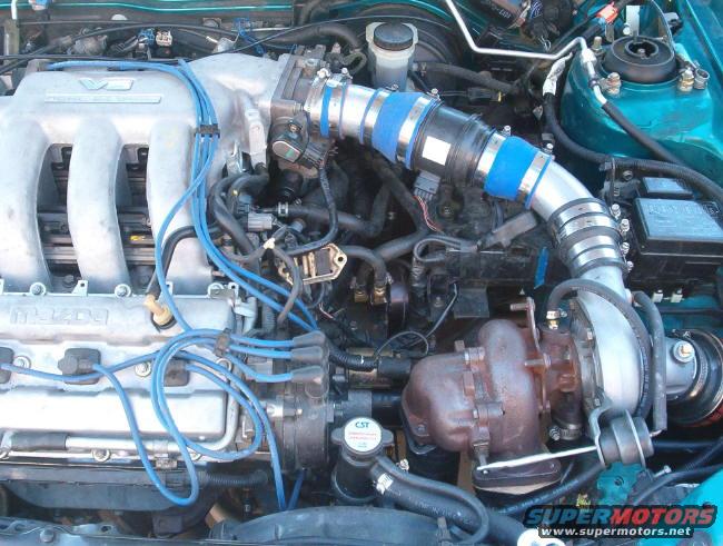 Engine bay with a turbocharger, intake piping, and Mazda branding on the intake manifold