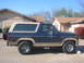 1986 Ford Bronco - A blue 1986 Ford Bronco is parked in front of a residential building.
