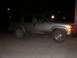 2000 Chevrolet Tahoe - A dirty SUV sits on a concrete surface at night, illuminated by streetlights.