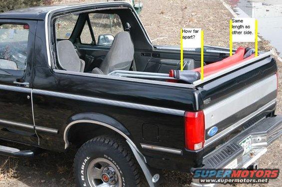 Black 1996 Ford Bronco rear side view with red and grey items in the bed