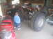 1983 Ford F-250 - Chassis of an off-road vehicle with large tires, next to a red motorcycle in a garage.
