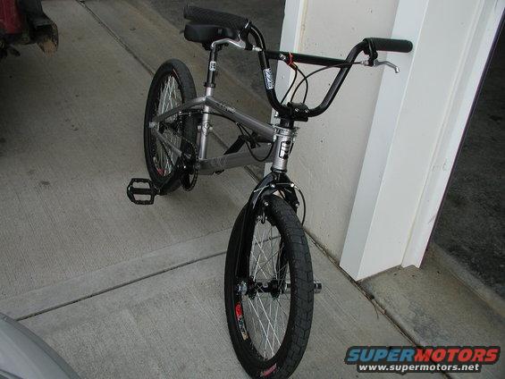 BMX bicycle parked on concrete, front wheel visible