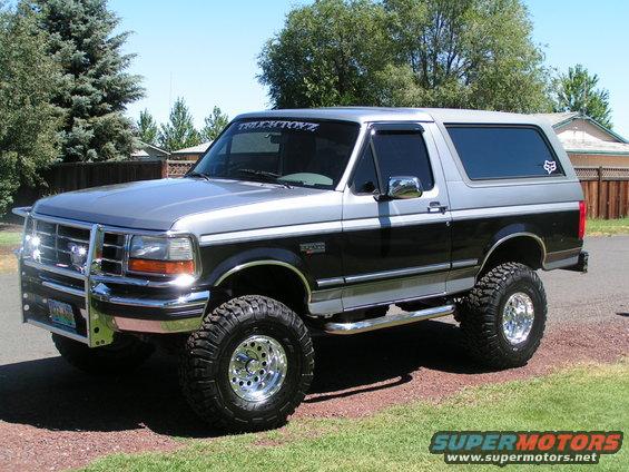 Silver and black lifted 1994 Ford Bronco with chrome bull bar and Fox logo sticker