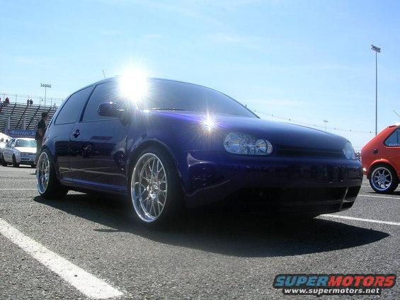 Purple hatchback with custom wheels parked on asphalt