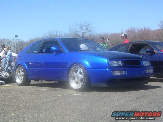Blue coupe with aftermarket wheels parked next to another car